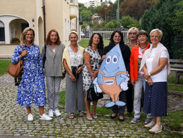 8 Frauen stehen mit Maskottchen Blubbi vor dem ENRW-Gebäude